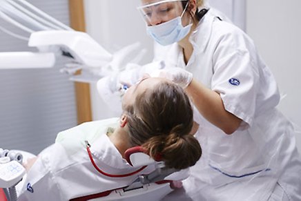 Tandhygienist tillsammans med patient i högskolans egna studentklinik